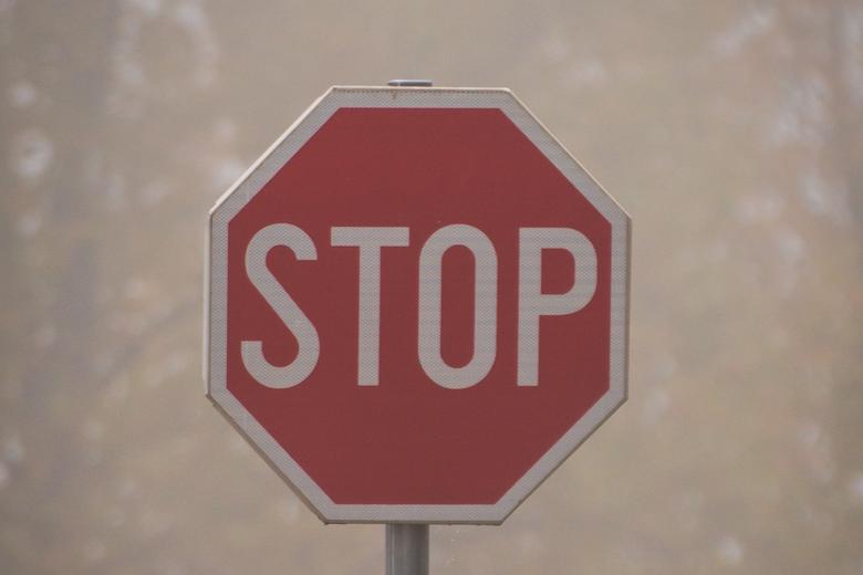 Red stop sign with a white blured background 
