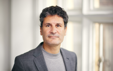Head and shoulders shot of Diego Sanchez Ancochea wearing a grey suit and top 