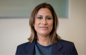Head and shoulders shot of Renu Gupta wearing a dark blue jacket 
